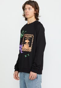 Zwarte sweatshirt met kleurrijke grafische print, teksten en diverse patronen, ronde hals, geribbelde boorden en een relaxte pasvorm.