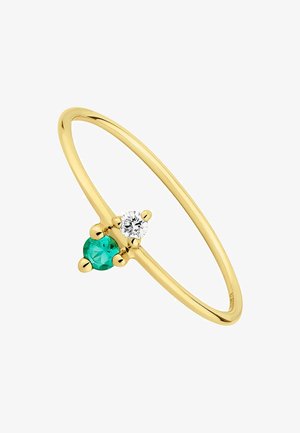 Anillo de oro con una banda lisa, adornado con una piedra verde y un diamante, cada uno sostenido por pequeños acentos esféricos.