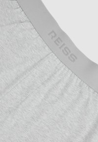 Šedé bavlnené boxerky s mäkkým pásom, na ktorom je vyrazené logo "REISS". Hladká textúra a minimalistický dizajn so subtílnym šitím.