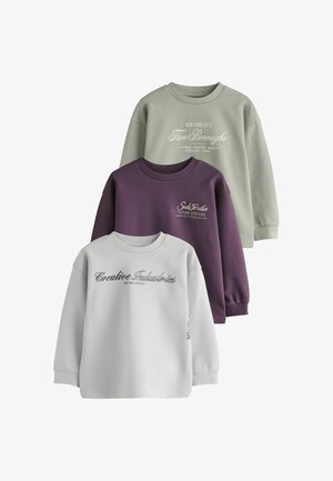 Trois sweat-shirts à col rond pliés en gris clair, violet foncé et vert clair avec texte imprimé sur le devant.