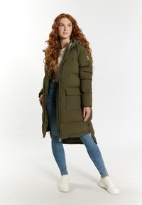 Jachetă puffer verde măsliniu cu glugă, fermoar frontal și buzunare mari. Are fermoare laterale și detaliu cu logo pe umăr.