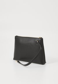 Porte-monnaie en cuir noir avec une texture lisse, de forme rectangulaire, fermeture à glissière sur le dessus et une dragonne amovible. Présence d'accents en métal doré.
