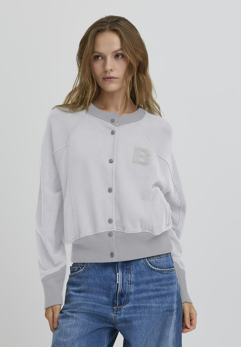 Light gray cropped cardigan made of soft fabric, featuring a round neck, button closure, and a textured "B" logo on the chest.