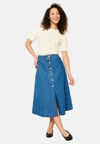 Denim A-lijn maxi rok met een voorknoopsluiting, met een hoge taille, een split en een medium blauwe kleur. Draag met een crèmekleurige top.