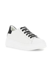 Valkoinen lenkkari, jossa on tekstuurilla varustettu musta kantapääkorostus, mustat nauhat ja paksu valkoinen pohja. Sujuva materiaali ja minimalistic muotoilu.