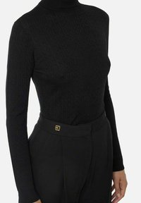 Bodysuit a collo alto nero con motivo testurizzato, vestibilità aderente, maniche lunghe, abbinato a pantaloni neri a vita alta con dettagli in oro.