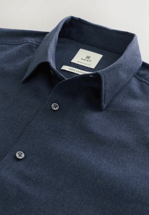 Sötét tengerészkék ing, 100% pamutból készült, galléros dekoltárral, két gombbal és normál szabással. Címke látható belül.