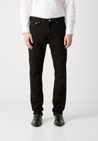 Jeans noirs avec une coupe droite, dotés d'un design classique à cinq poches, de quincaillerie en métal et d'une texture en denim lisse. Assortis à des chaussures noires.