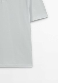 T-shirt gris clair à manches courtes avec un ourlet droit, présenté sur un fond blanc montrant le dessus et la manche.