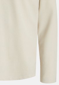 Long-sleeve, ribbed knit top in light beige. Features textured fabric with slight sheen, standard cuffs, and a straight hem.