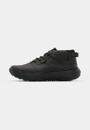 Scarpe da hiking nere con una tomaia testurizzata, accentuazioni rinforzate e una suola robusta. Presentano lacci elastici e un linguetta sul tallone.