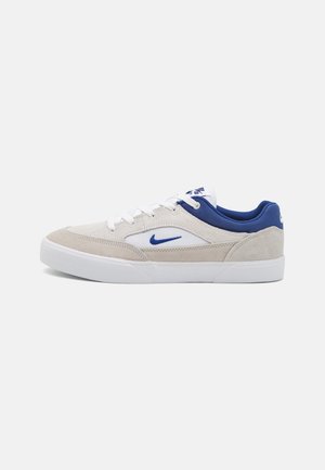 Baskets avec un dessus en daim beige, des détails en textile blanc, des accents bleus au talon et une semelle en caoutchouc blanc. Logo emblématique de Nike en swoosh.