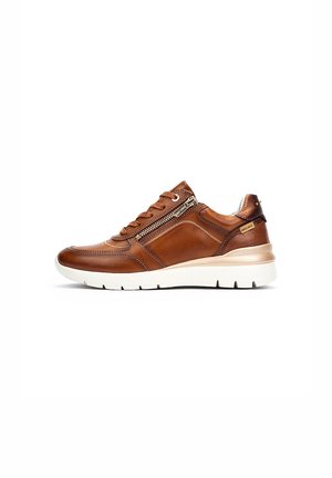 Sneaker en cuir marron avec semelle en caoutchouc blanche, fermeture à lacets à l'avant, détail de zip sur le côté et accents beiges. Texture lisse avec des coutures minimales.