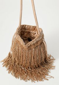 Beaded handbag in beige with fringe detailing, featuring a satin interior and shoulder strap. Pleated top opening reveals a lined interior.