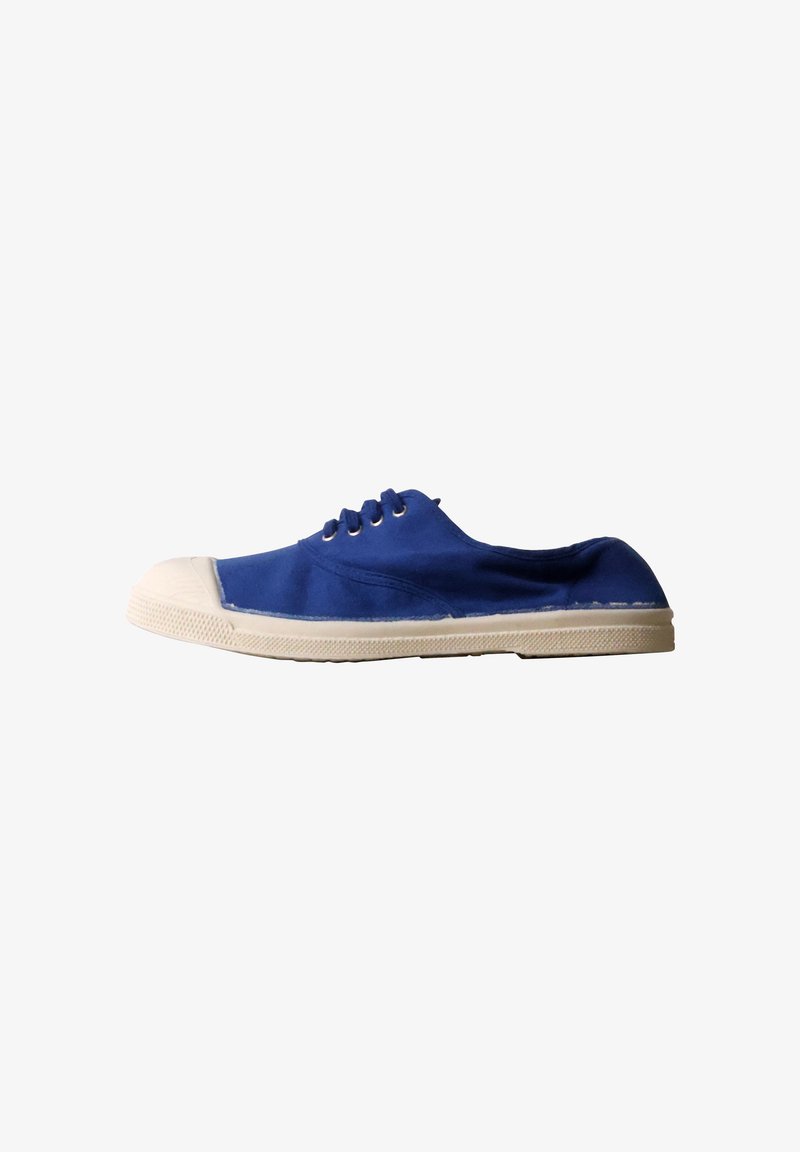 Une chaussure de toile bleue unique avec une semelle et un embout en caoutchouc blanc, vue de côté sur fond blanc.