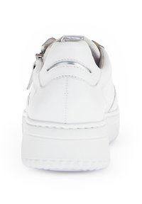 Weiße Ledersneaker mit glatter Oberfläche, runder Form, dicker Sohle und silbernem Reißverschlussakzent. Die Rückansicht zeigt die Nähdetails und die strukturierte Ferse.