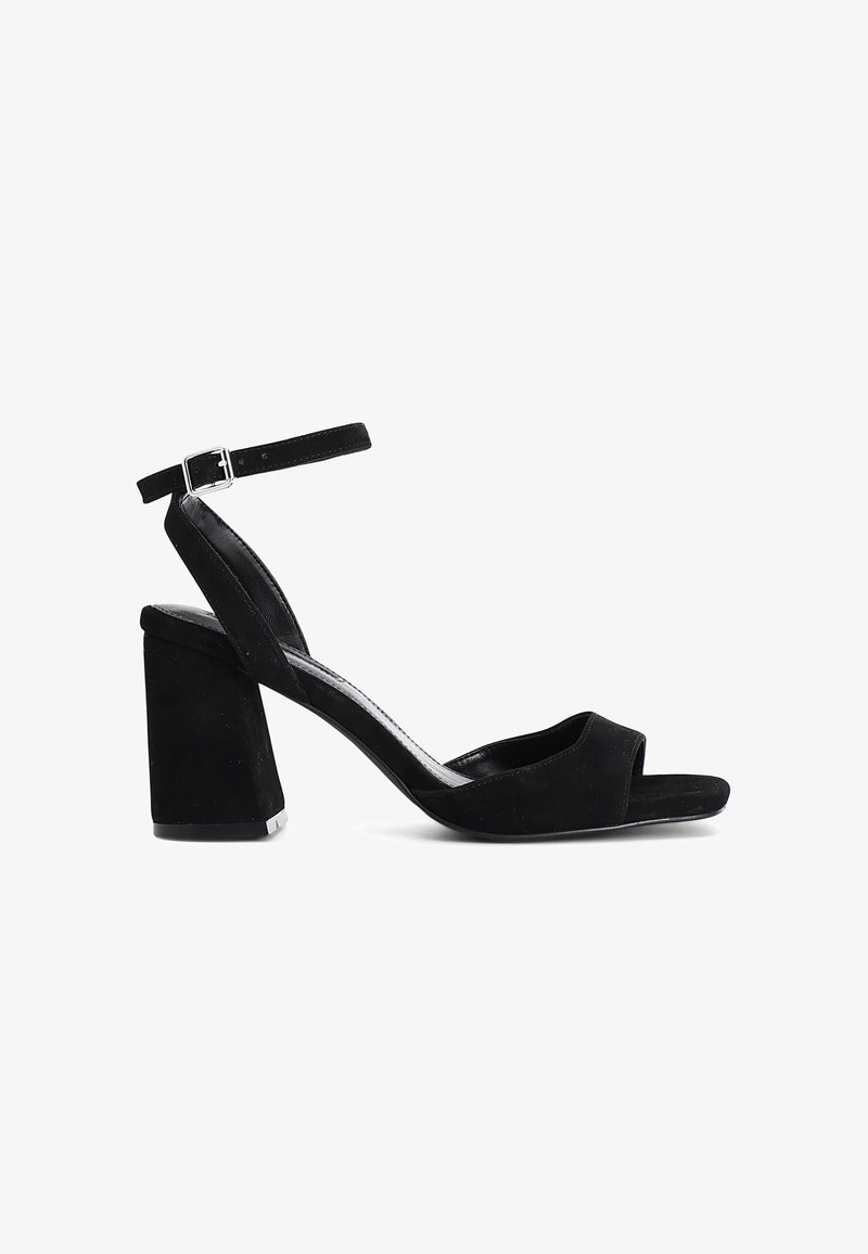 Černé semišové sandály na vysokém podpatku s blokovým podpatkem, otevřenou špičkou a nastavitelním páskem na kotníku. Hladká textura a minimalistický design.
