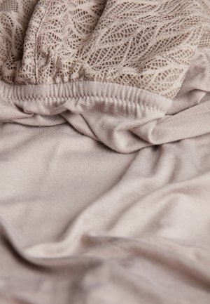Lace top with a textured pattern in sandy beige over a smooth, light-toned fabric. Features gathered elastic at the waistband.