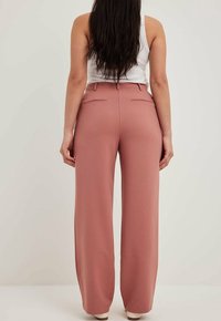 Rosa vida byxor med skräddarsydd design, som har två bakfickor och en mjuk tygstruktur. Lämpliga för både vardags- och formella tillfällen.