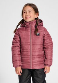 Veste isolante rose avec capuche, dotée de coutures horizontales, d'un zip frontal et d'un patch logo noir. Portée sur un pantalon noir.