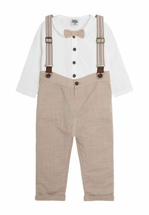 Pantalones beige con puños enrollados, tirantes marrones ajustables y una camisa blanca de manga larga con un pajarita y detalles en botones.