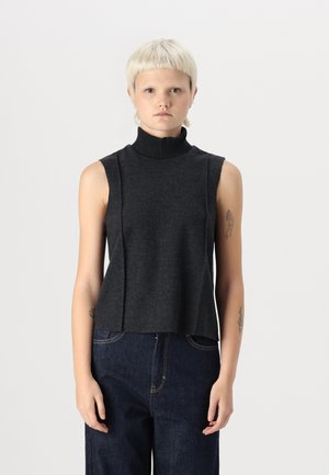 Dark gray sleeveless top with a high ribbed collar, featuring a relaxed fit and two vertical seam details on the front. Paired with dark jeans.