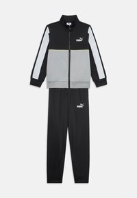 Zwart en grijs trainingspak met een jack met rits, een hoge kraag en witte accenten, gecombineerd met bijpassende zwarte broek, beide met logo.