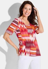 Kleurige T-shirt met korte mouwen, versierd met een levendig zigzagpatroon in rode, roze en oranje tinten, met een ronde halslijn en een getailleerde pasvorm.