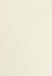 Tessuto beige chiaro con una texture liscia e una leggera elasticità, caratterizzato da un design semplice senza motivi o decorazioni.