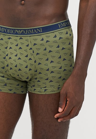 Zelene bokserice z mornarsko modrim vzorcem emblema, ki imajo udoben pas z blagovno znamko "Emporio Armani". Mehka in raztegljiva tkanina.