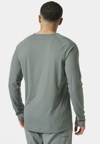 Lange mouwen shirt in lichtgrijs, met een gestructureerde stof, ronde halslijn en platte naden met raglanmouwen voor optimale bewegingsvrijheid.