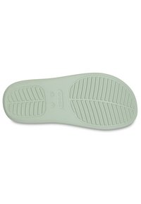 Suola di scarpa in gomma verde chiaro con linee di grip testurizzate e motivi a foglia, caratterizzata da un logo centrale e dettagli stampati vicino al tallone.