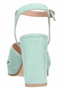 Mintgroene suède hoge hak sandaal met een robuuste hak, verstelbare enkelband en kruislings ontwerp aan de voorkant. Gladde textuur.