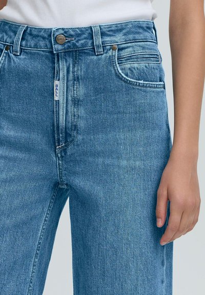 Svetlomodré rifle z denimu s klasickým dizajnom piatich vreciek, vybavené zapínaním na gombík, rovnými nohavicami a jemným detailom pomačkania.