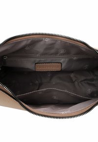 Brown leather bag interior featuring a zip pocket, lined with dark fabric and repeating logo pattern, detailed stitching, and zip closure.