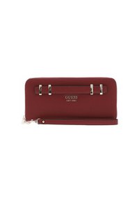 Burgunderfarbene Guess Zip-around Geldbörse mit Handgelenkband, silberfarbigem Metallzubehör und eingeprägtem Logo "GUESS EST 1981" auf der Vorderseite.