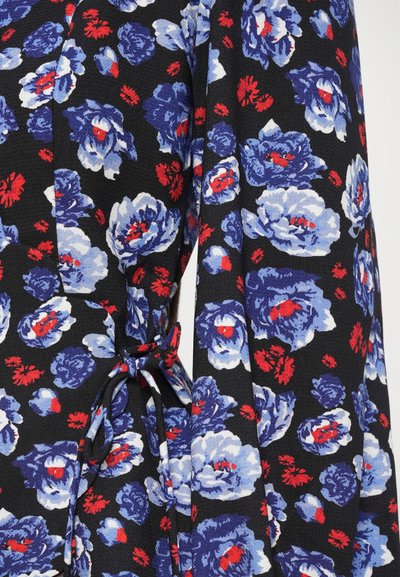 Abito floreale con sfondo nero decorato da grandi fiori blu e rossi. Il tessuto ha un aspetto strutturato, con un dettaglio in vita annodato.