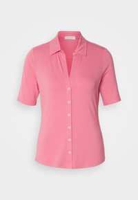 Chemise rose à manches courtes boutonnée avec col, en tissu doux, présentée sur fond blanc.