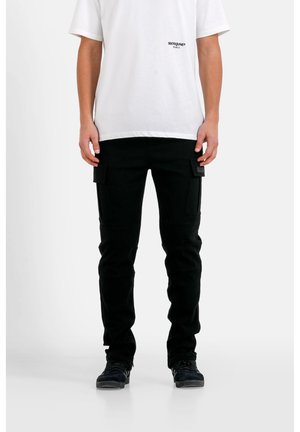 Schwarze Cargo-Hosen mit zwei seitlichen Taschen, schmaler Schnitt und elastischem Bund, kombiniert mit einem weißen T-Shirt mit kleinem Logo.