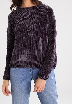 Dark purple, textured knit sweater with a rounded neckline and long sleeves, paired with light blue distressed jeans.