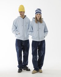 Šviesiai mėlynos zip-up džinsinės striukės, mėlynos džinsinės kelnės su tamsesniais mėlynais grafikos raštais, geltonos ir mėlynos megztos kepurės, įvairūs avalynės stiliai.