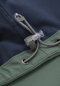 Marinfärgad tyg med en texturerad yta, innehållande en grön sektion, silverdetaljer och en genomskinlig justeringsknapp för anpassad passform.