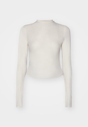 Lys beige langermet topp med høy hals, laget av mykt, elastisk stoff, med en flatterende silhuett og buet kant.