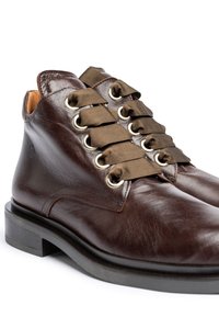 Bruine lederen enkelboots met een ronde neus, slanke zwarte rubberen zool en olijfgroene satijnen veters door metalen oogjes.