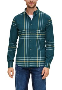 Teal overhemd met witte en gele ruitpatroon; lange mouwen, kragen en één borstzak. Draagt met blauwe spijkerbroek.