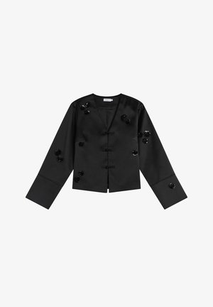 Zwarte satijnen cropped jas met lange mouwen, voorzien van decoratieve ronde embellissementen en een voorkant met sluiting met zwarte toggels.