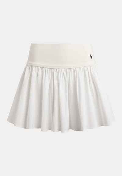 Hvit plissert tennisnederdel med bred linning og en liten svart brodert polo-spillerlogo på høyre side.