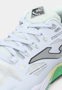 Basket de sport bleu clair avec une tige en maille, des accents argentés et une semelle texturée distincte comportant des éléments verts et jaunes.