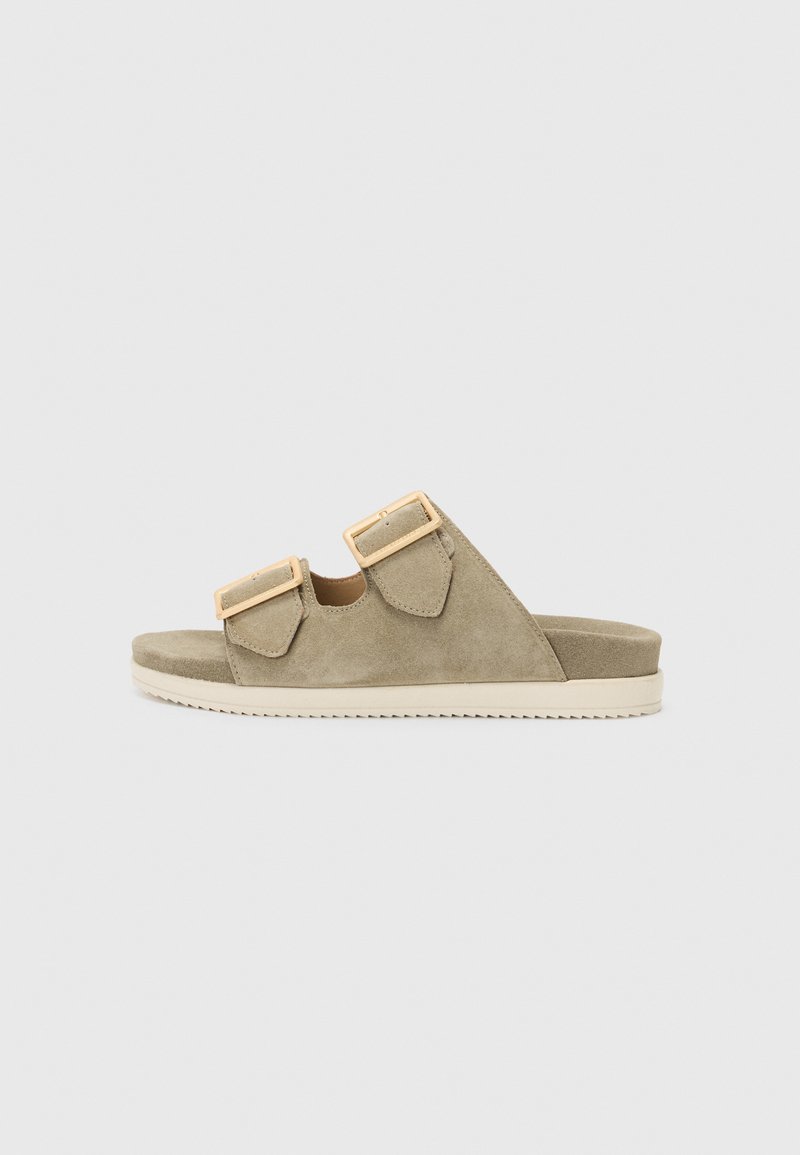 Khaki suede sandals with two adjustable straps and gold-tone buckles, featuring a flat sole and textured footbed for comfort.