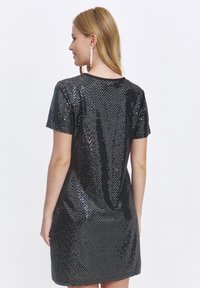 Schwarzes Pailletten-Kleid mit taillierter Silhouette, kurzen Ärmeln und Rundhalsausschnitt. Glatte Textur mit reflektierender Oberfläche.